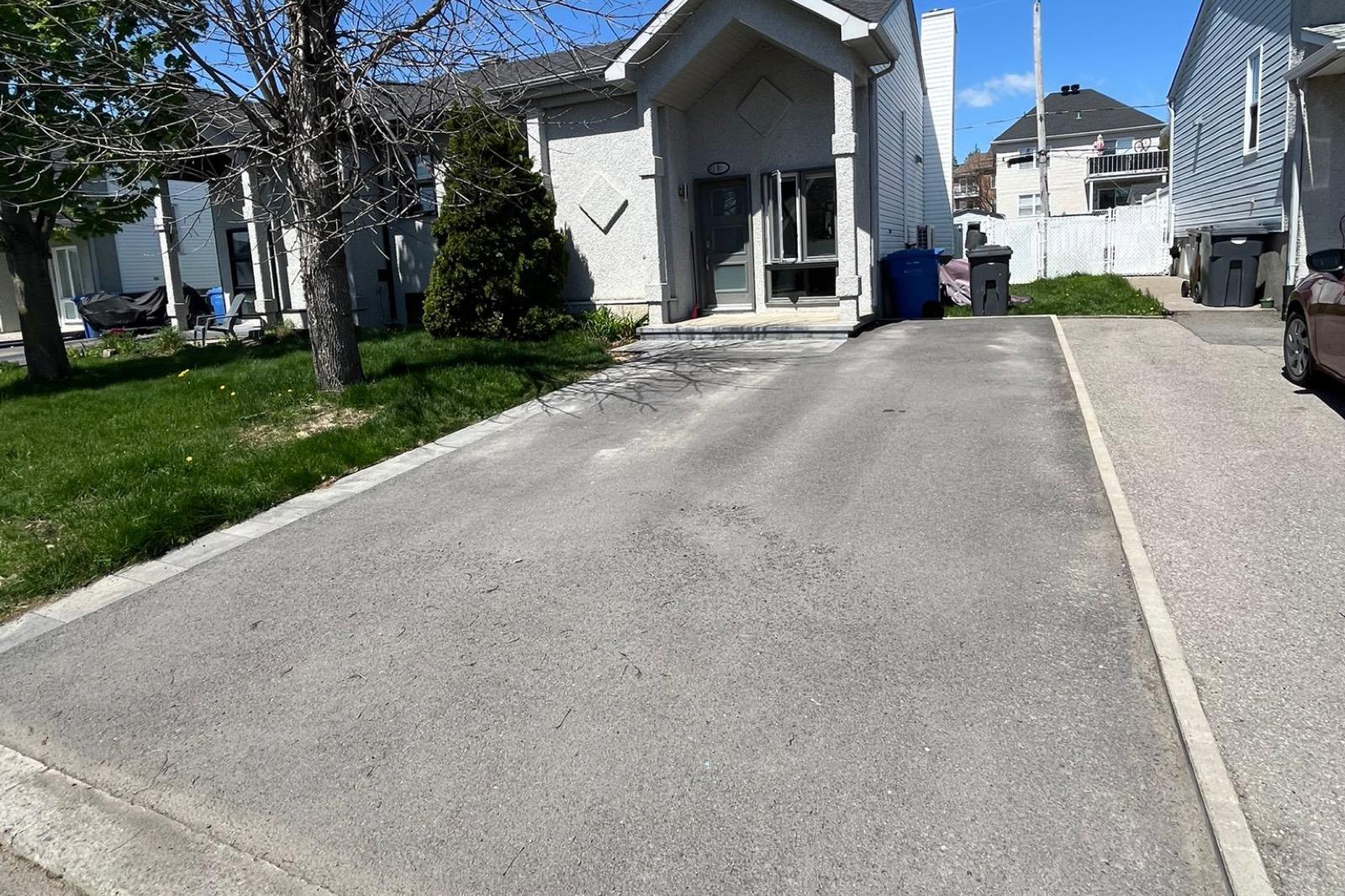 Freshly sealed driveway — uniform black finish — Before